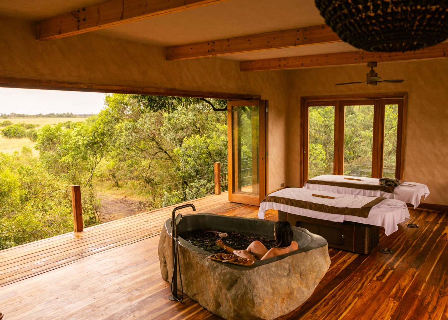 A round timber bath in a room open to green country beyond