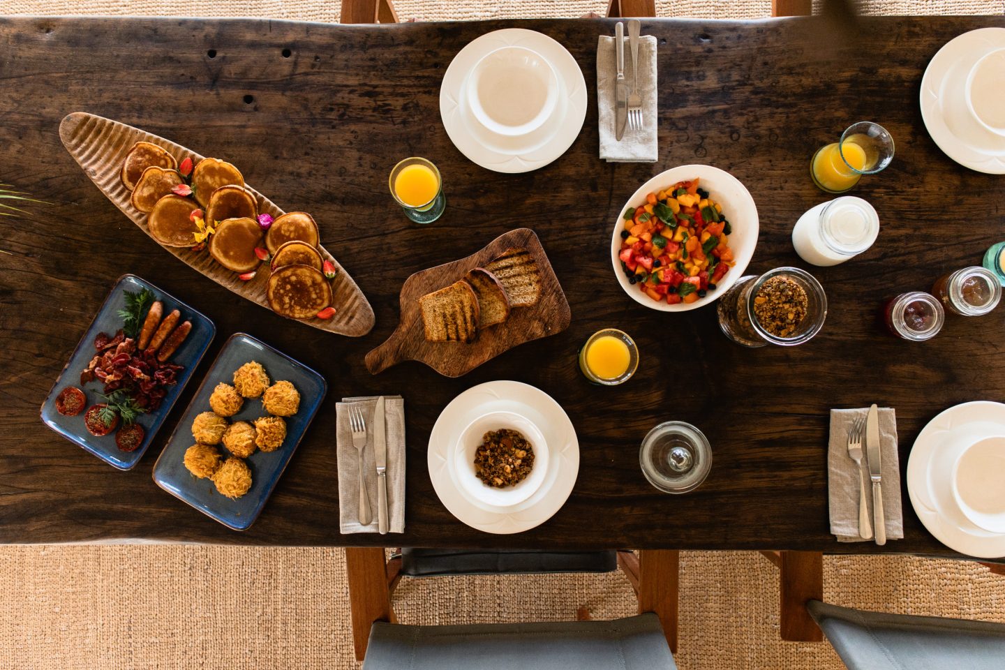 Dishes and breads laid across a table, photographed from above
